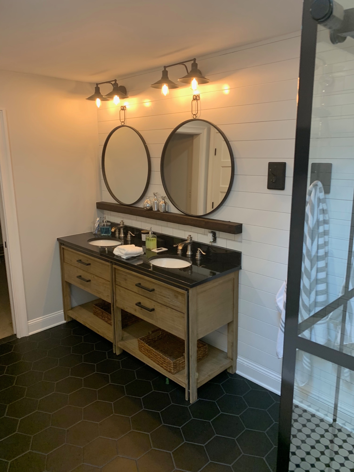 Primary bathroom vanity with dual mirrors and black hex floor tile
